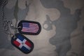 army blank, dog tag with flag of united states of america and dominican republic on the khaki texture background. Royalty Free Stock Photo