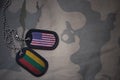 army blank, dog tag with flag of united states of america and lithuania on the khaki texture background.