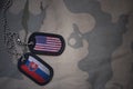 army blank, dog tag with flag of united states of america and slovakia on the khaki texture background.