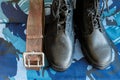 Army boots and army belt on blue camouflage fabric. Overalls for the soldier