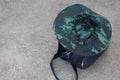 army green striped fabric hat Placed on the outdoor cement floor