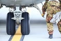 An army mechanic is inspecting the landing gear of a military cargo plane Royalty Free Stock Photo