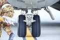 An army mechanic is inspecting the landing gear of a military cargo plane Royalty Free Stock Photo