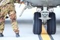 An army mechanic is inspecting the landing gear of a military cargo plane Royalty Free Stock Photo