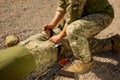 Army medics practice applying a tourniquet to the leg of a wounded soldier.