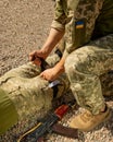 Army medics practice applying a tourniquet to the leg of a wounded soldier.