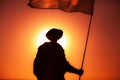 Army soldier with waving flag on sunset background