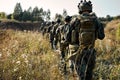 Army soldiers team in combat uniform and helmets goign on countryside road Royalty Free Stock Photo