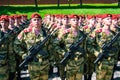 Army of soldiers with weapons. A squad of fighters in red berets and green uniforms. Russian troops with rifles