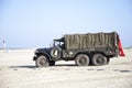 Army trucks of organization Kelly's Heroes riding on beach