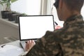 Army. Young soldier working with a laptop computer with blank screen on black background. Royalty Free Stock Photo