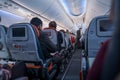 Steward with protective mask service on air travel and passengers wait on seats in Turkish Airlines flight in quarantine days