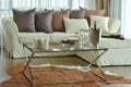 Aroma candles and wine glasses on the table with beige sofa and deep brown pillows in living room