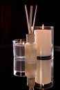 Aroma diffuser and scented candles on table with reflectio. Romantic setting