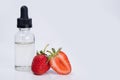 Aroma and flavor enhancer next to ripe strawberries, on white background Royalty Free Stock Photo