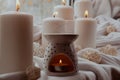 Aroma lamp with essential oil, aromatherapy at home, burning candle, dropping essential oil. Concept of home relaxation