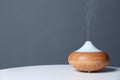 Aroma oil diffuser lamp on table against gray background Royalty Free Stock Photo