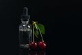 Aroma oils in a can with a dispenser, next to the fruit of ripe cherries. lying on black background Royalty Free Stock Photo