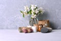 Aroma spa treatment background with handmade soap, aroma candles, flowers, aromatic oils and stones on the shelf