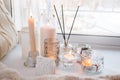 Aroma stick near window with candles in the morning, winter spring cozy light monochrome background