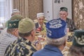 Local residents of Siberian village celebrate Muslim holiday Kurban Bayram at their home table. Mullah saying prayer