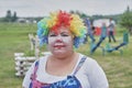 Woman in clown makeup and multi-colored curly wig