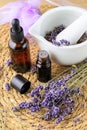 Lavender, sachet of dried flowers, bottle of essential oil and mortar on straw background Royalty Free Stock Photo