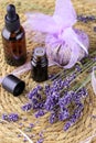 Aromatherapy composition with lavender, sachet of dried flowers and bottle of essential oil on straw