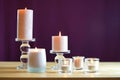 Aromatherapy composition with pink candles on table against purple background