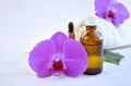 Aromatherapy concept with essential oil bottle, dropper, and orchid flowers. Royalty Free Stock Photo