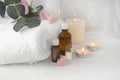 Aromatherapy concept with essential oil bottle, sea salt, burning candles and towel. Royalty Free Stock Photo