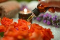 Aromatherapy Essential Oil Dropper with Fresh Roses and Burning Candle on Spa Table Royalty Free Stock Photo