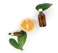 Aromatherapy and heathcare composition with orange essential oil bottle, fresh citrus and leaves on white background.