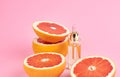 Aromatherapy - Pure essential oil in bottle with fresh grapefruit halves