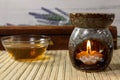 Aromatherapy, scented lamp with a candle in the form of a water lily, green tea and incense stick Royalty Free Stock Photo