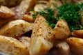 Aromatic baked potato wedges with fresh dill herbs. Homemade rustic dish, delicious hearty food close up