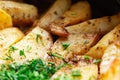 Aromatic baked potato wedges with fresh dill herbs. Homemade rustic dish, delicious hearty food close up