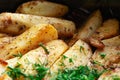 Aromatic baked potato wedges with fresh dill herbs. Homemade rustic dish, delicious hearty food close up