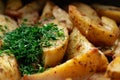 Aromatic baked potato wedges with fresh dill herbs. Homemade rustic dish, delicious hearty food close up