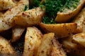 Aromatic baked potato wedges with fresh dill herbs. Homemade rustic dish, delicious hearty food close up