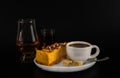 Aromatic black coffee in white cup with cheesecake on white saucer, single malt, and coffee liqueur, brown sugar, teaspoon, black Royalty Free Stock Photo