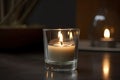 aromatic candle burning in a modern clear glass votive holder
