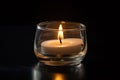 aromatic candle burning in a modern clear glass votive holder