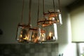 Aromatic candles in glass jars hanging in kitchen.