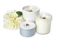 Aromatic candles with wooden wicks and beautiful flowers on white background Royalty Free Stock Photo