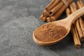 Aromatic cinnamon powder and sticks on grey table, closeup. Space for text Royalty Free Stock Photo