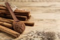 Aromatic cinnamon powder and sticks on wooden table, closeup. Space for text Royalty Free Stock Photo