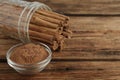 Aromatic cinnamon powder and sticks on wooden table, closeup. Space for text Royalty Free Stock Photo