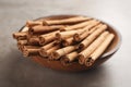 Aromatic cinnamon sticks in bowl on grey stone table, closeup Royalty Free Stock Photo