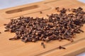 Aromatic cloves magnified on a wooden kitchen board, spices and aromas. Large depth of field